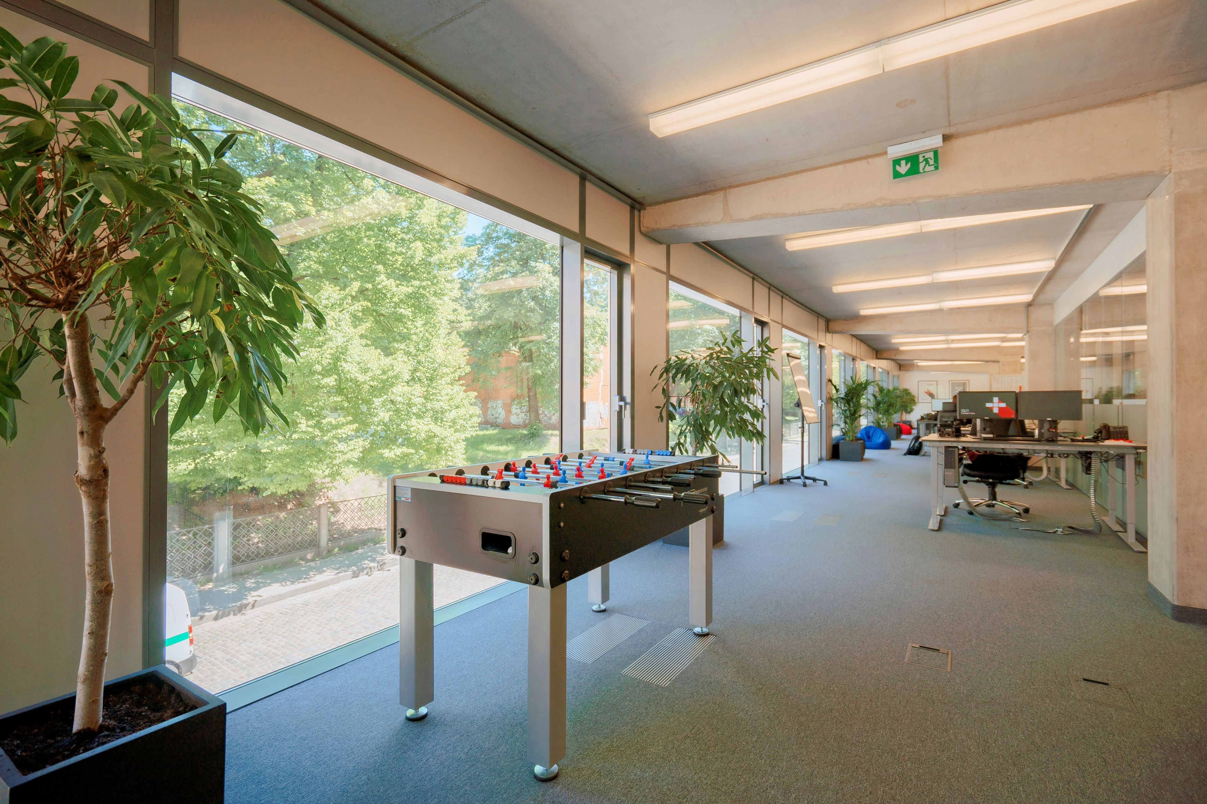 a room with a foosball and a potted plant
